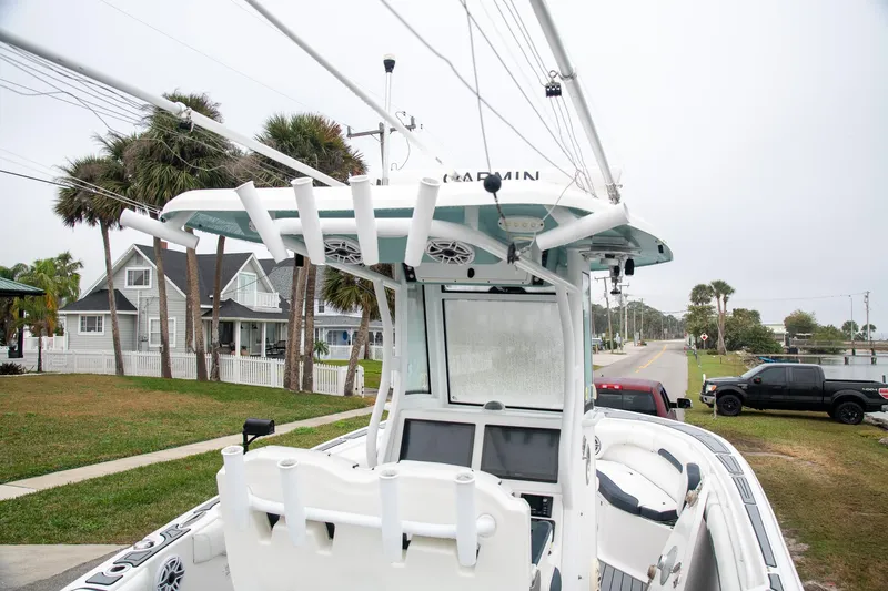  Yacht Photos Pics 2021 Tidewater 280 CC Adventure boat parked near residential area with palm trees.