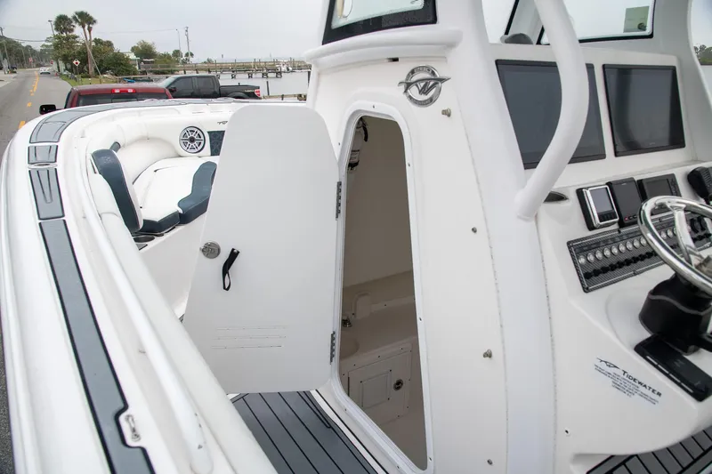  Yacht Photos Pics 2021 Tidewater 280 CC Adventure boat interior with open cabin door and control panel.