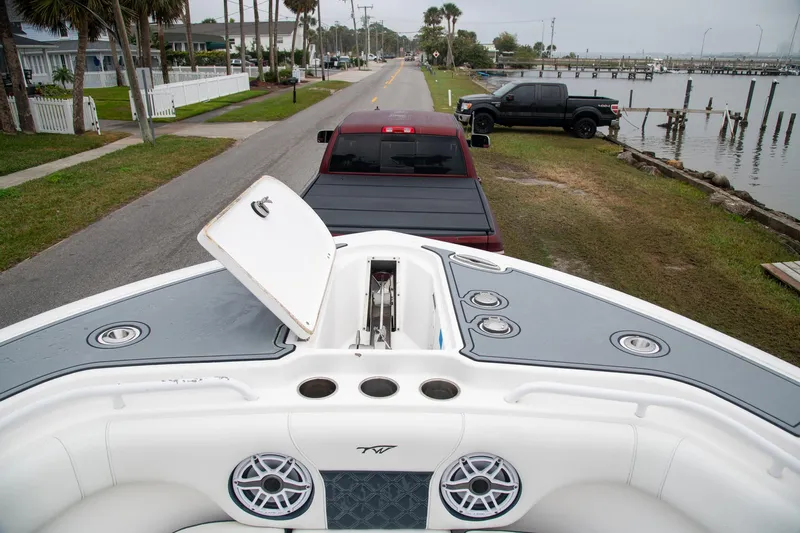  Yacht Photos Pics 2021 Tidewater 280 CC Adventure boat on trailer, parked near waterfront road.