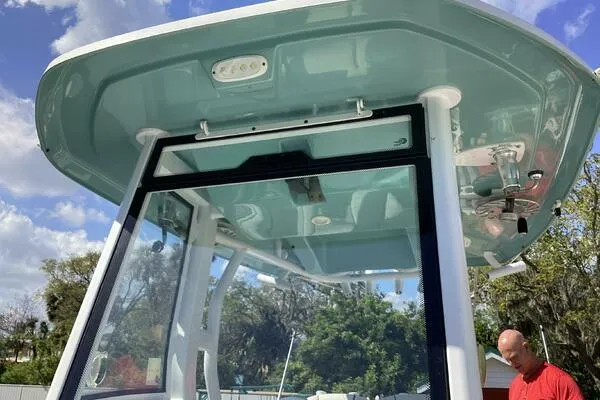  Yacht Photos Pics 2021 Tidewater 280 CC Adventure boat with T-top, clear skies, and trees in the background.