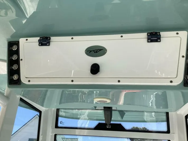  Yacht Photos Pics 2021 Tidewater 280 CC Adventure boat interior with storage compartment and control panel.