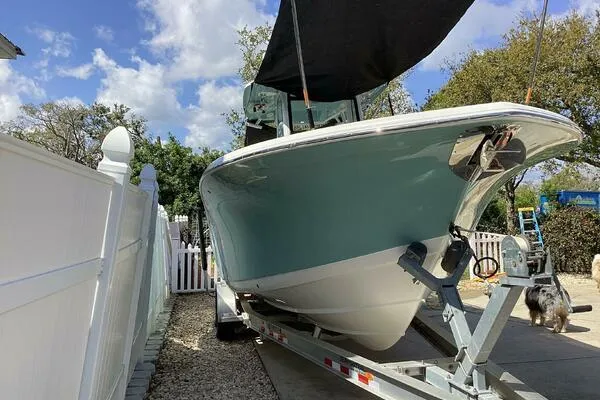  Yacht Photos Pics 2021 Tidewater 280 CC Adventure boat on trailer, parked outdoors under blue sky.