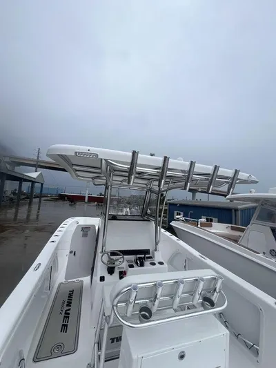  Yacht Photos Pics 2024 Twin Vee 280 STX boat with sleek design and modern features, docked under cloudy skies.