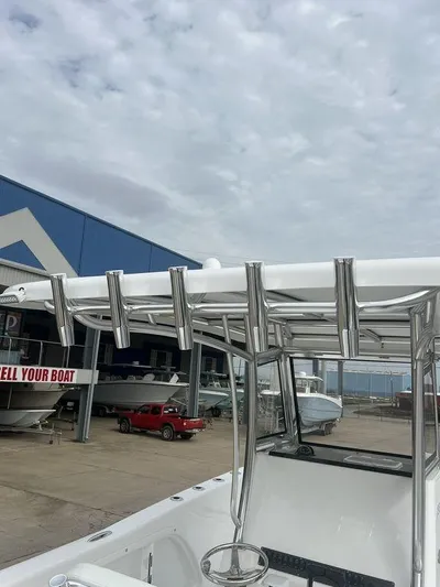  Yacht Photos Pics 2024 Twin Vee 280 STX boat with T-top and rod holders at a marina.