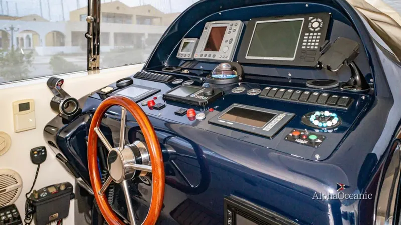  Yacht Photos Pics Helm of 2004 Uniesse 57 yacht with navigation instruments and wooden steering wheel.