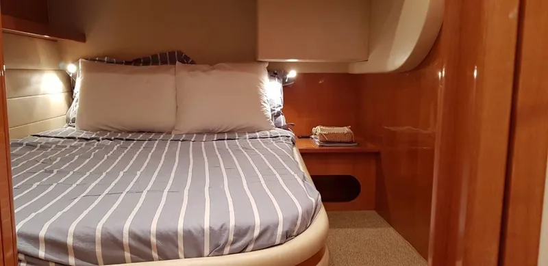  Yacht Photos Pics Luxurious cabin interior of 2004 Uniesse 57 yacht with striped bedding.