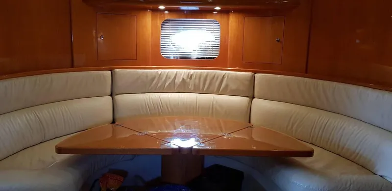  Yacht Photos Pics Luxurious interior of 2004 Uniesse 57 yacht with elegant seating and wooden table.