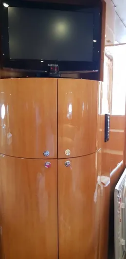  Yacht Photos Pics 2004 Uniesse 57 yacht interior with wooden cabinetry and mounted TV.