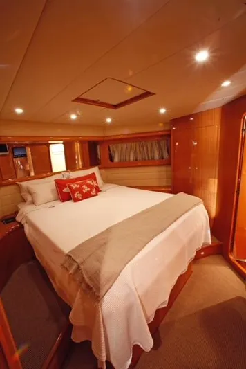  Yacht Photos Pics Luxurious cabin interior of a 2004 Uniesse 57 yacht with cozy bedding and warm lighting.