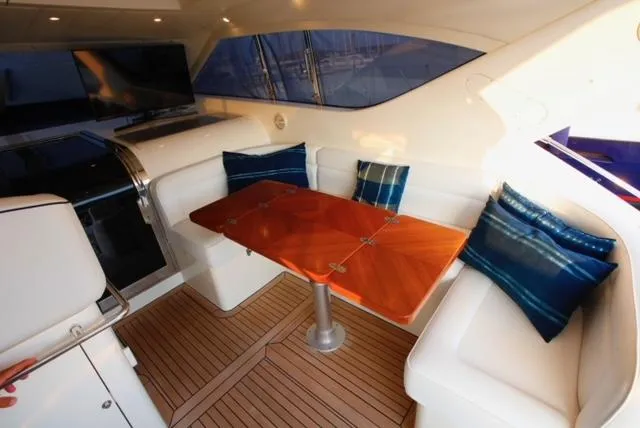  Yacht Photos Pics Luxurious 2004 Uniesse 57 yacht interior with elegant seating and wooden table.