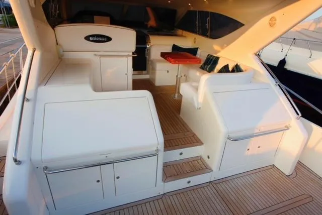  Yacht Photos Pics 2004 Uniesse 57 yacht deck with seating, table, and storage compartments.