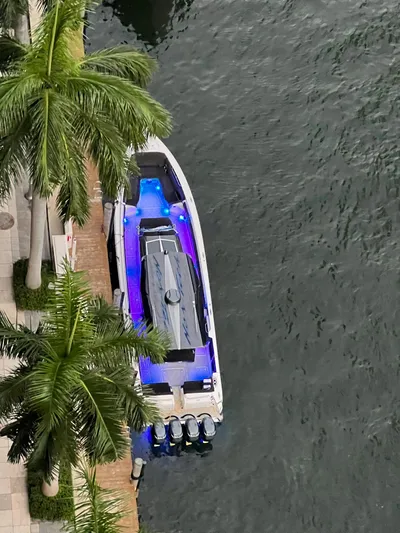  Yacht Photos Pics 2019 Nor-Tech 450 Sport boat docked by palm trees with blue interior lights.