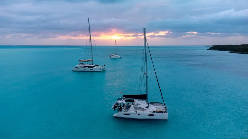 Selah Yacht Photos Pics Sailboats anchored in turquoise waters at sunset, featuring a 2010 Leopard 38 catamaran.