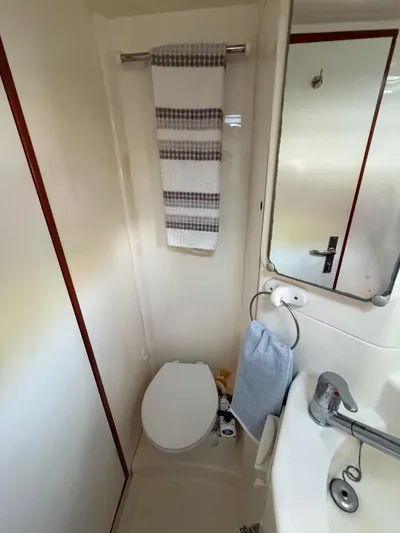 Selah Yacht Photos Pics Compact bathroom in a 2010 Leopard 38 yacht with toilet, sink, and towel rack.