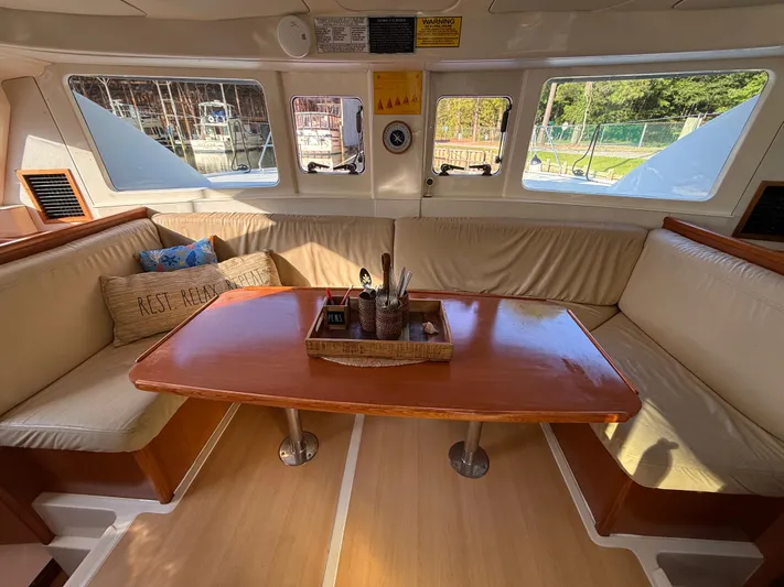 Selah Yacht Photos Pics Cozy interior of 2010 Leopard 38 catamaran with wooden table and cushioned seating.