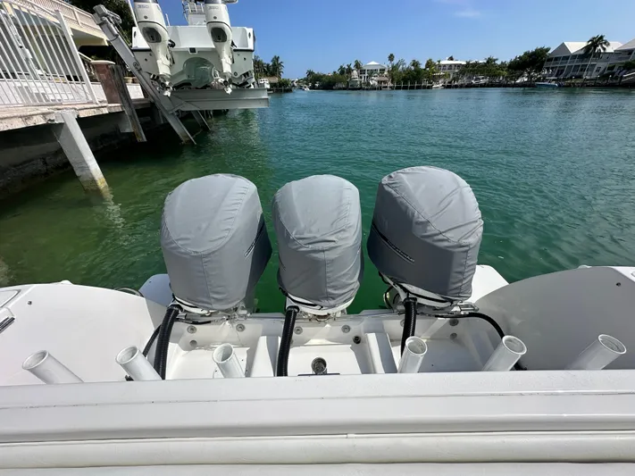  Yacht Photos Pics 2015 Intrepid 400 Center Console with triple outboard engines, docked in a serene waterfront setting.