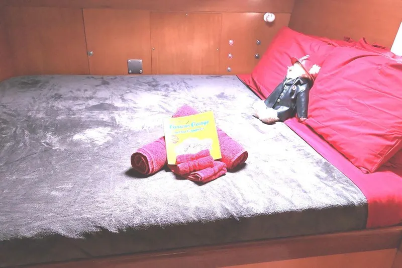 Guiding Light Yacht Photos Pics Cozy cabin bed in 1997 Lagoon 410 catamaran with red pillows and towels.