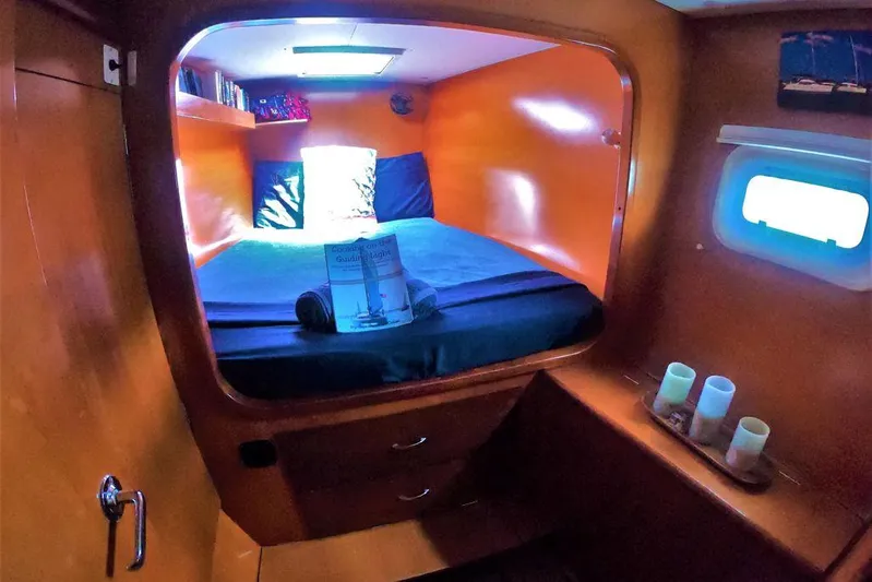 Guiding Light Yacht Photos Pics Cozy cabin interior of 1997 Lagoon 410 catamaran with bed and porthole.