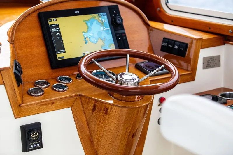 Calm Yacht Photos Pics 1999 Hinckley Picnic Boat Classic helm with wooden steering wheel and navigation display.
