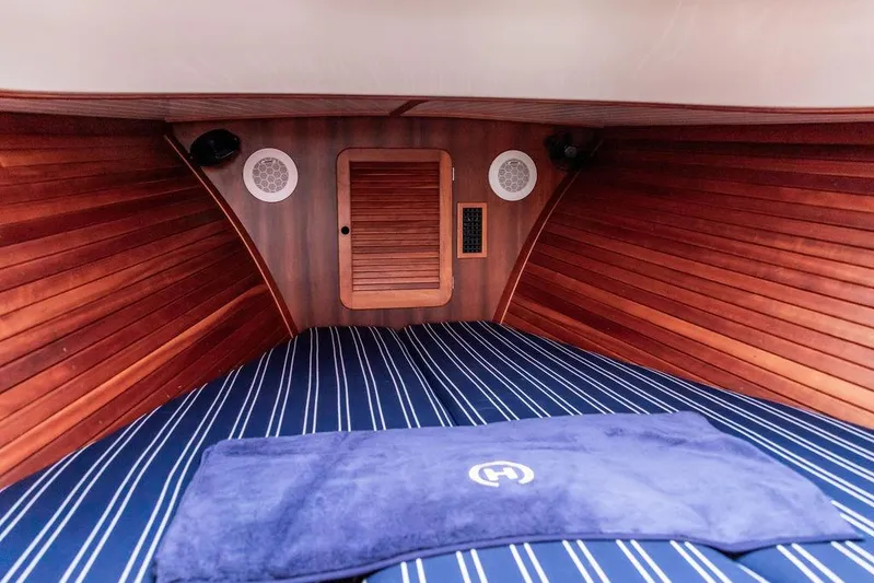 Calm Yacht Photos Pics 1999 Hinckley Picnic Boat Classic cabin interior with wood paneling and striped bedding.