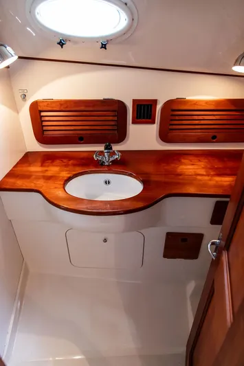 Calm Yacht Photos Pics 1999 Hinckley Picnic Boat Classic bathroom with wooden cabinetry and sink.
