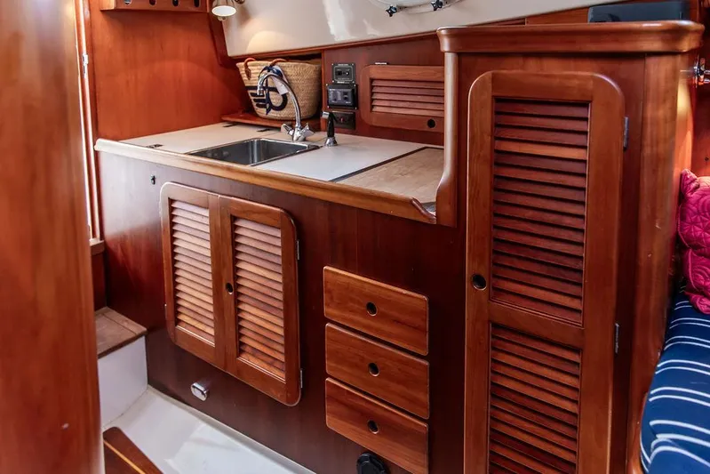 Calm Yacht Photos Pics 1999 Hinckley Picnic Boat Classic interior with wooden cabinetry and compact kitchen area.