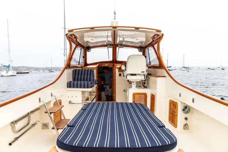 Calm Yacht Photos Pics 1999 Hinckley Picnic Boat Classic with striped seating, docked in a marina.