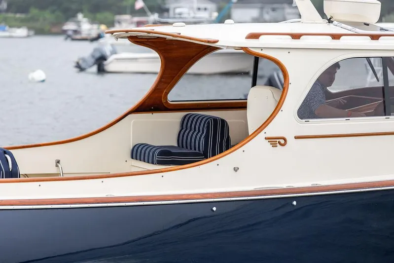 Calm Yacht Photos Pics 1999 Hinckley Picnic Boat Classic with striped seating, cruising on a calm waterway.