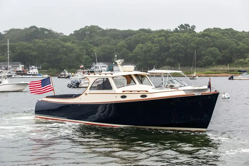 Calm Yacht Photos Pics 1999 Hinckley Picnic Boat Classic cruising on a calm lake with American flag.