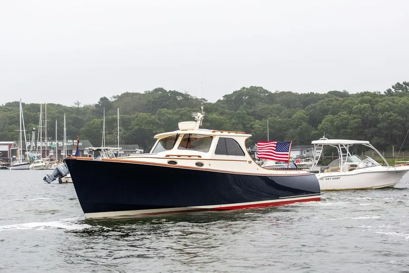 Calm Yacht Photos Pics 1999 Hinckley Picnic Boat Classic cruising in a marina, American flag displayed, overcast day.