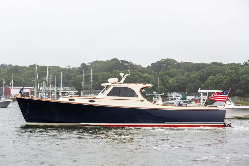 Calm Yacht Photos Pics 1999 Hinckley Picnic Boat Classic cruising in a marina, displaying an American flag.
