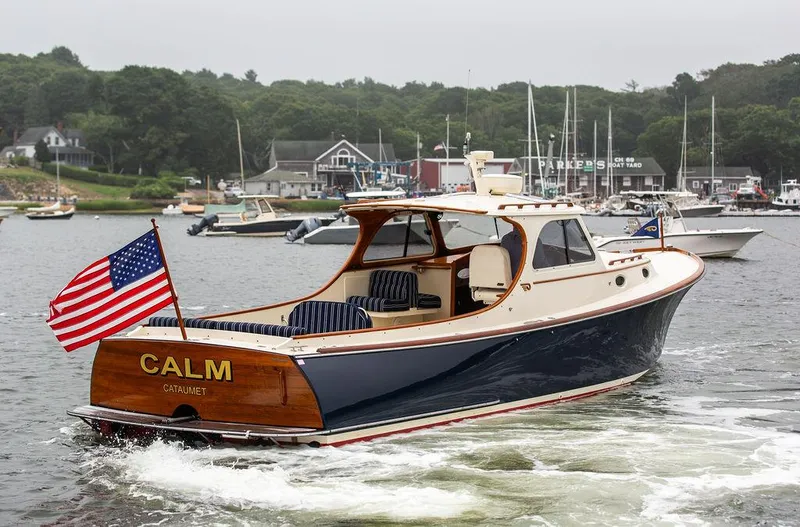 Calm Yacht Photos Pics 1999 Hinckley Picnic Boat Classic cruising in a scenic harbor with American flag.