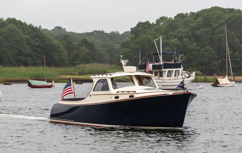 Calm Yacht Photos Pics 1999 Hinckley Picnic Boat Classic cruising on a serene lake with lush green surroundings.