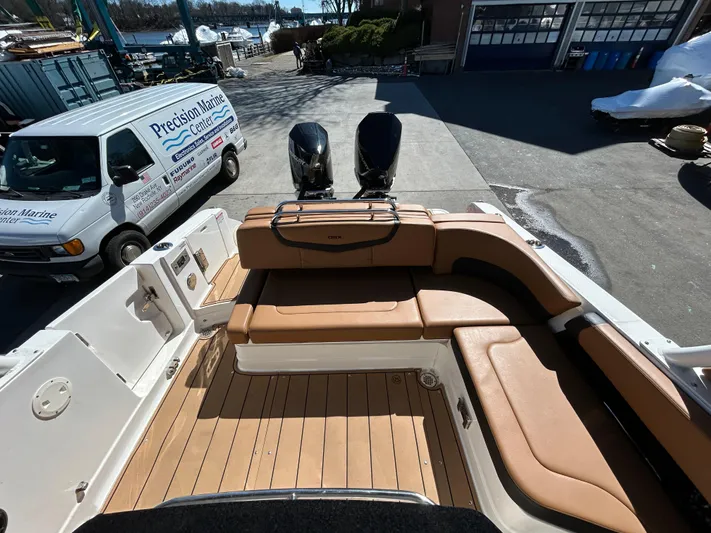  Yacht Photos Pics 2023 Chaparral 300 OSX boat with tan seating and twin engines at a marina.