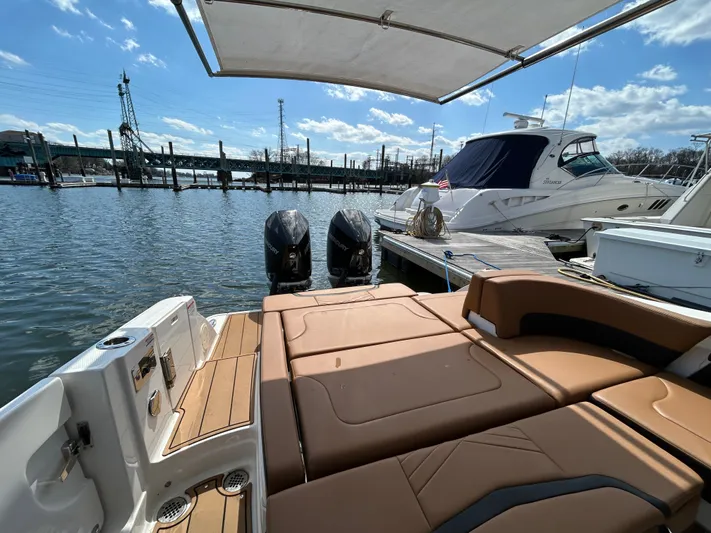  Yacht Photos Pics 2023 Chaparral 300 OSX boat docked, featuring spacious deck and twin engines.