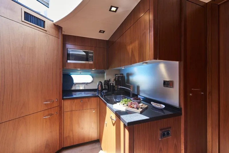  Yacht Photos Pics Luxurious 2010 Sunseeker Predator 64 yacht kitchen with wood cabinetry and modern appliances.