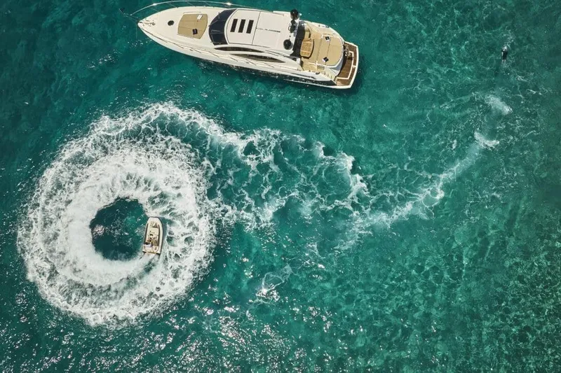  Yacht Photos Pics Aerial view of 2010 Sunseeker Predator 64 yacht on turquoise water with swirling wake.
