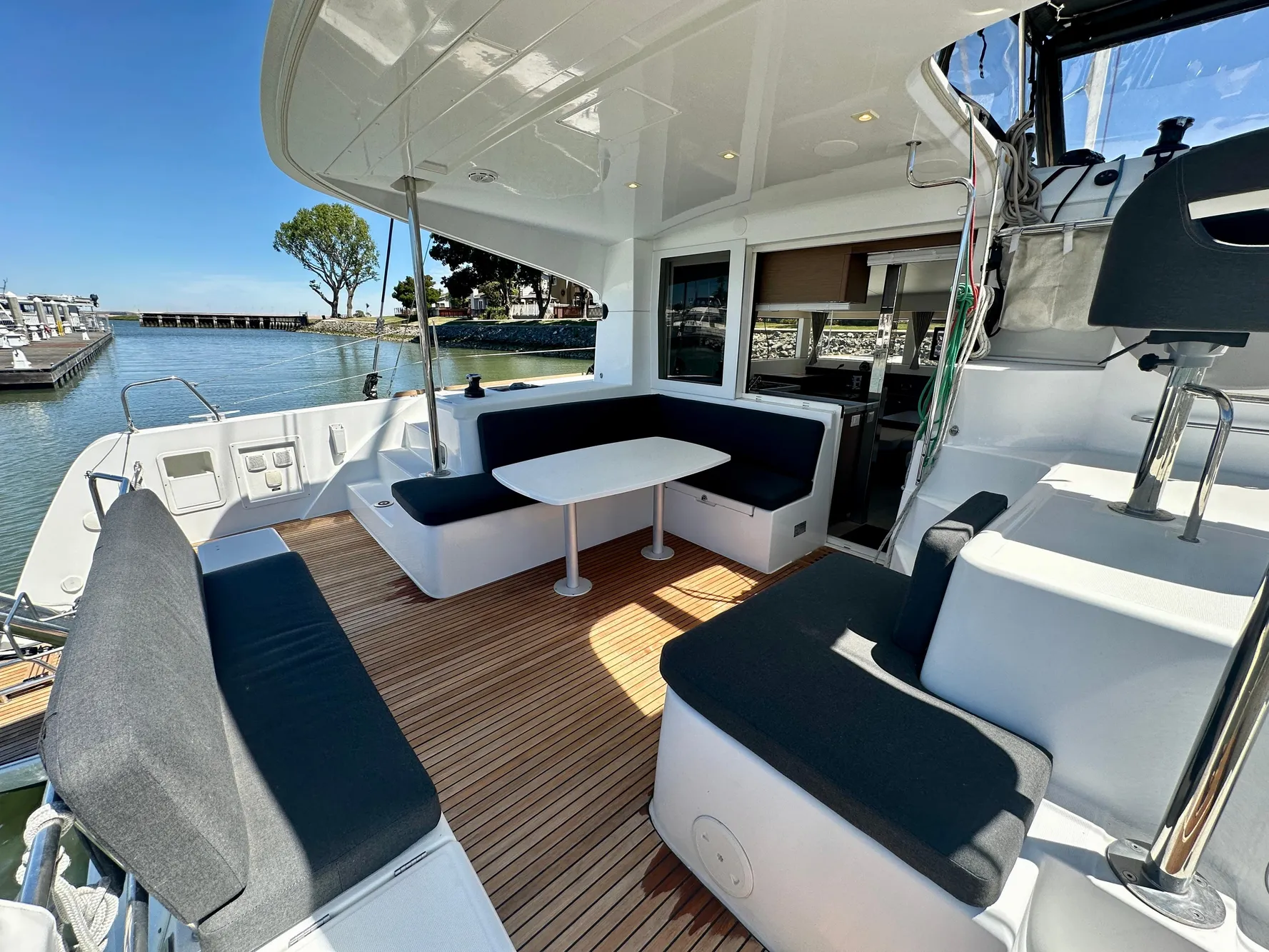 Outdoor seating area on a 2020 Lagoon 40 catamaran with a scenic marina view.