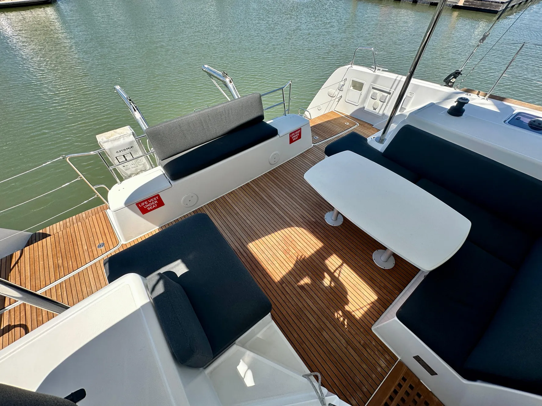 2020 Lagoon 40 catamaran deck with seating and table, docked on calm water.