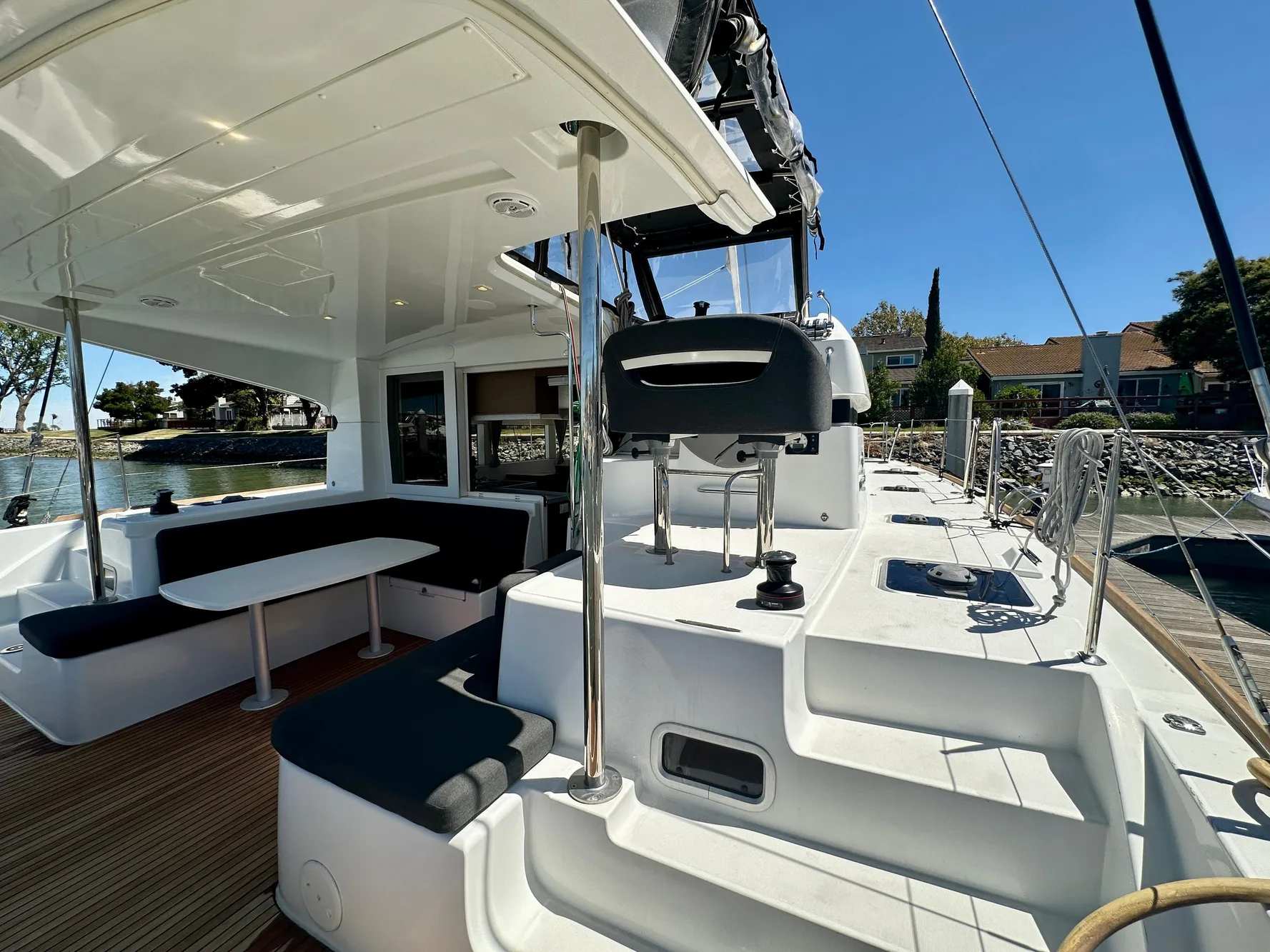 2020 Lagoon 40 catamaran with spacious deck, seating area, and helm station, docked by the water.