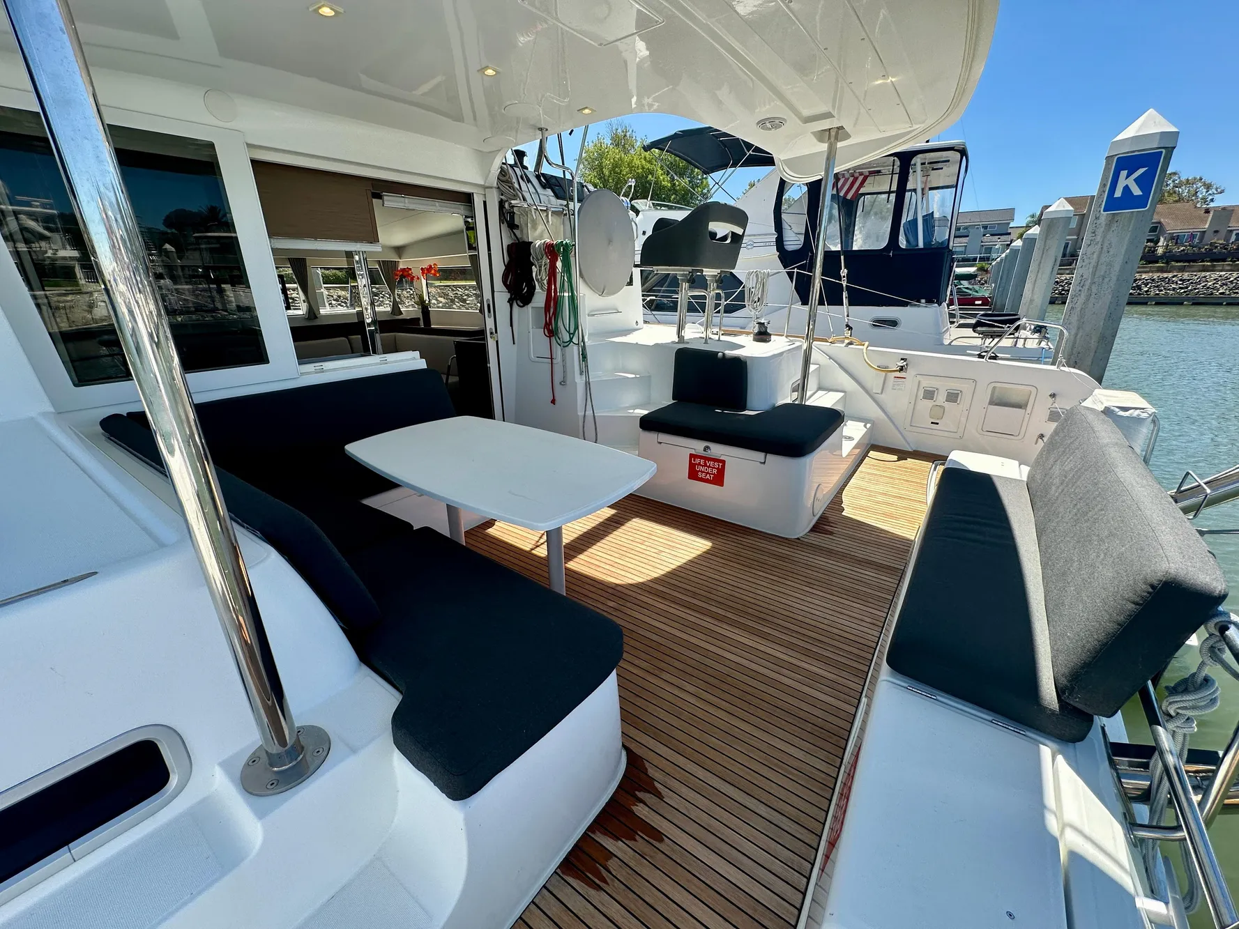 Lagoon 40 catamaran 2020 model with spacious deck, seating, and table in marina setting.