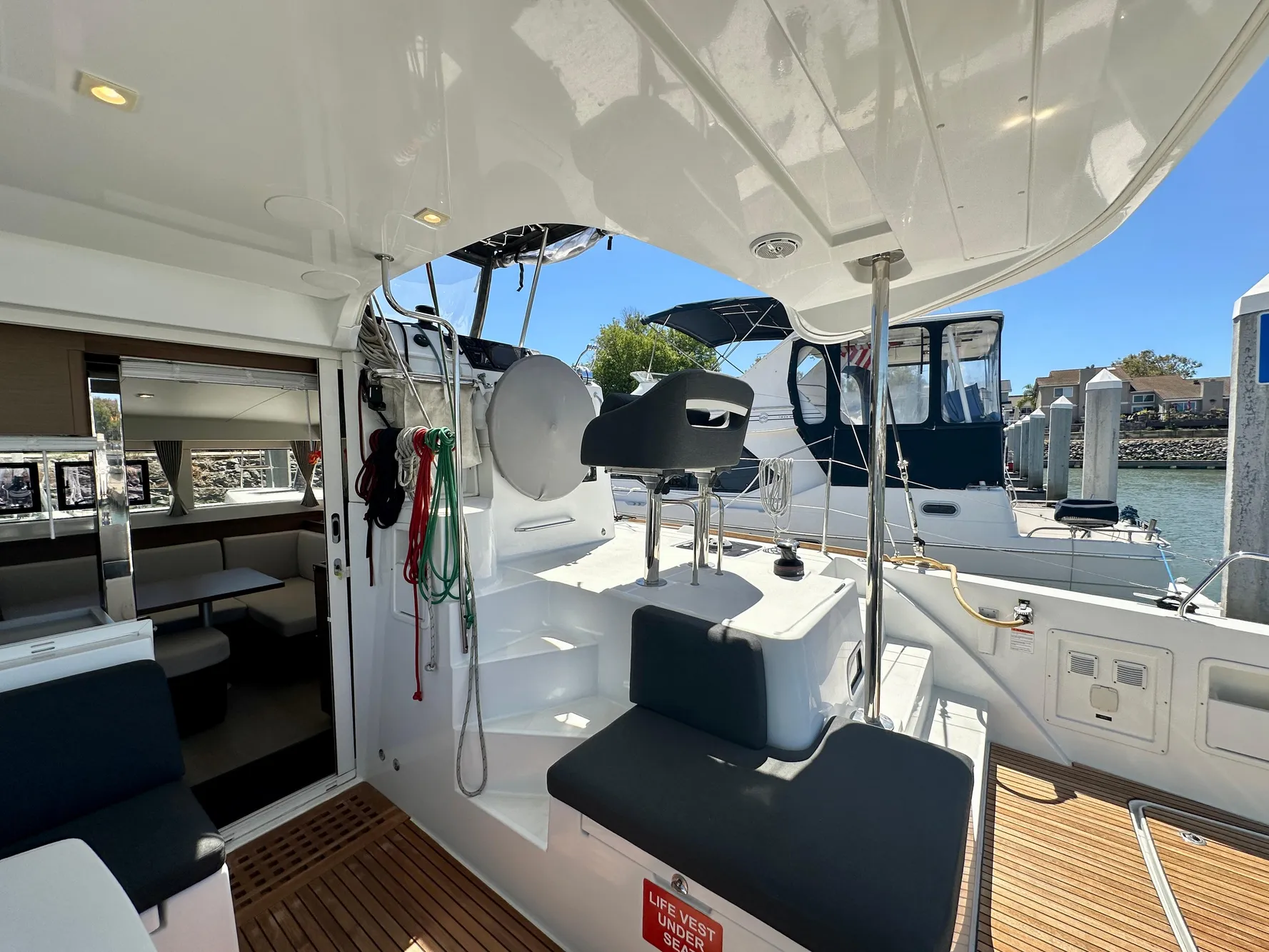 2020 Lagoon 40 catamaran cockpit with seating, helm, and marina view.