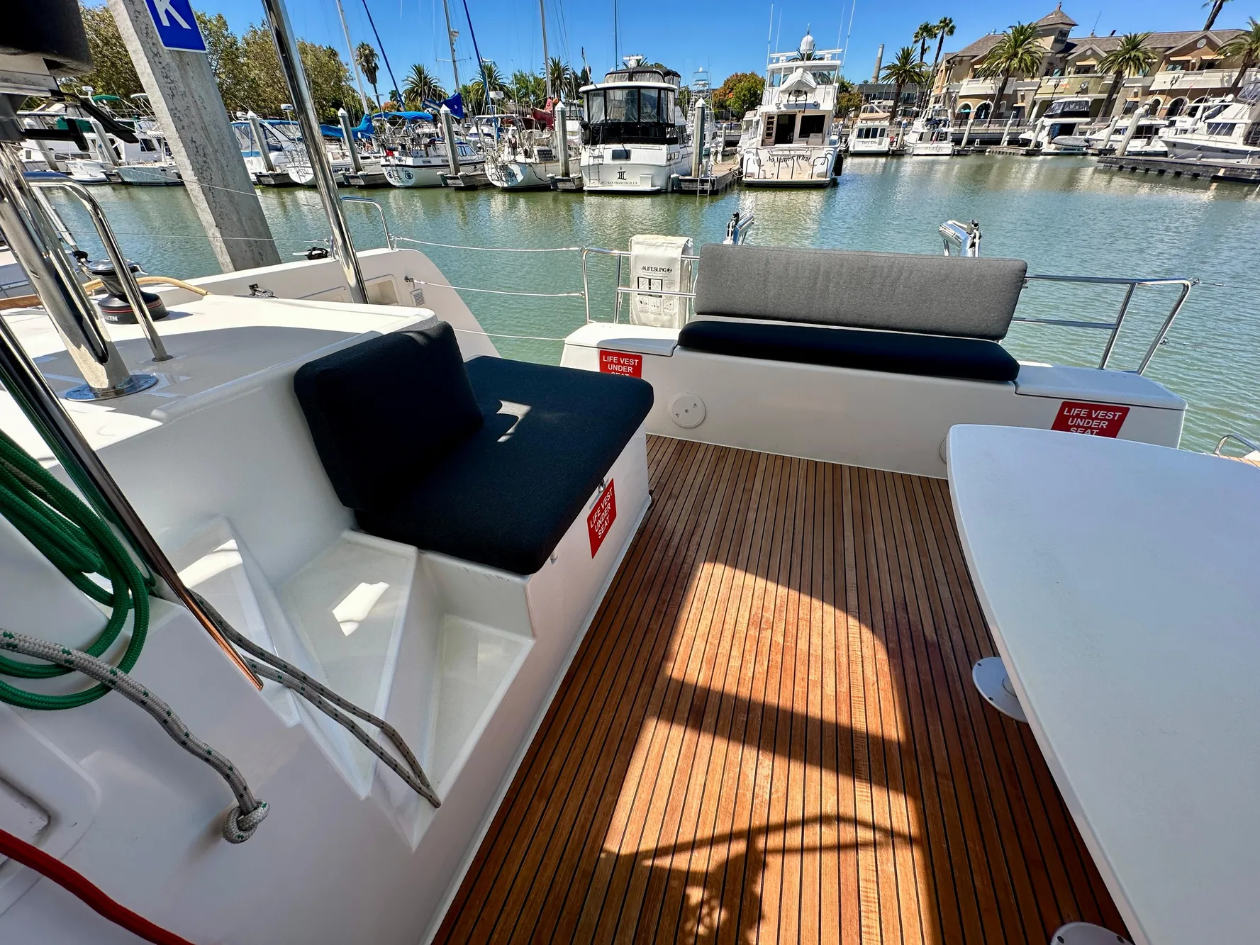 2020 Lagoon 40 catamaran deck with seating, docked at marina with yachts.