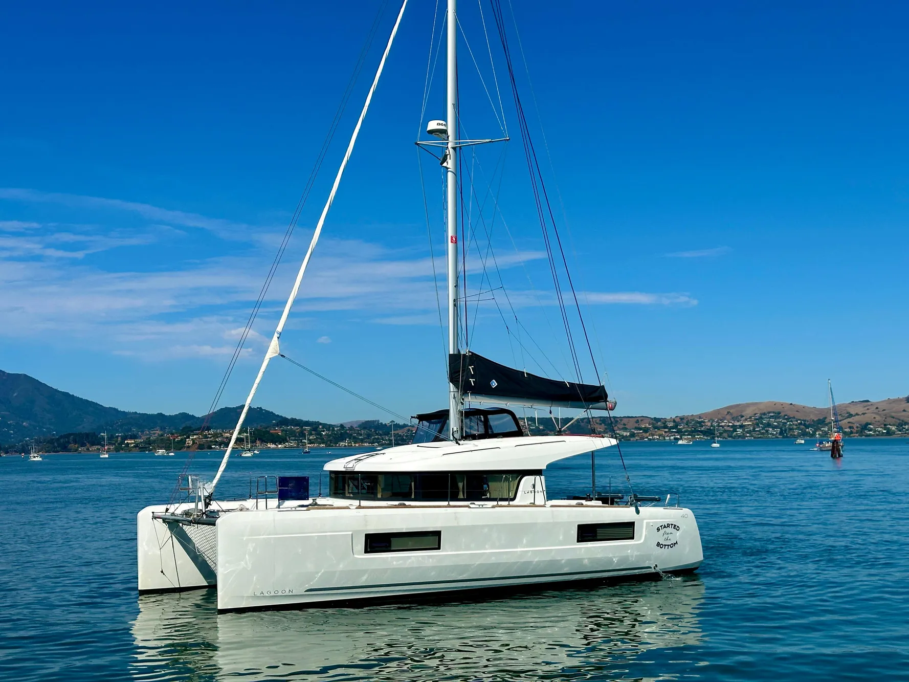 2020 Lagoon 40 catamaran sailing on calm waters under a clear blue sky.