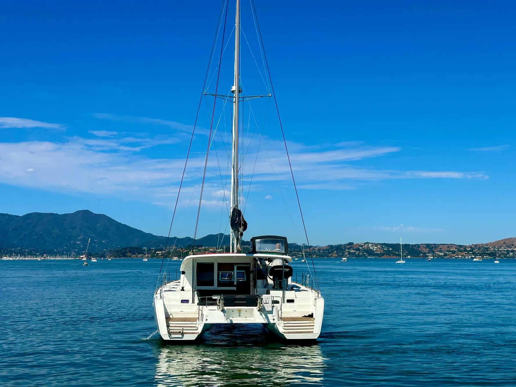 2020 Lagoon 40 catamaran on calm water with scenic mountain backdrop.
