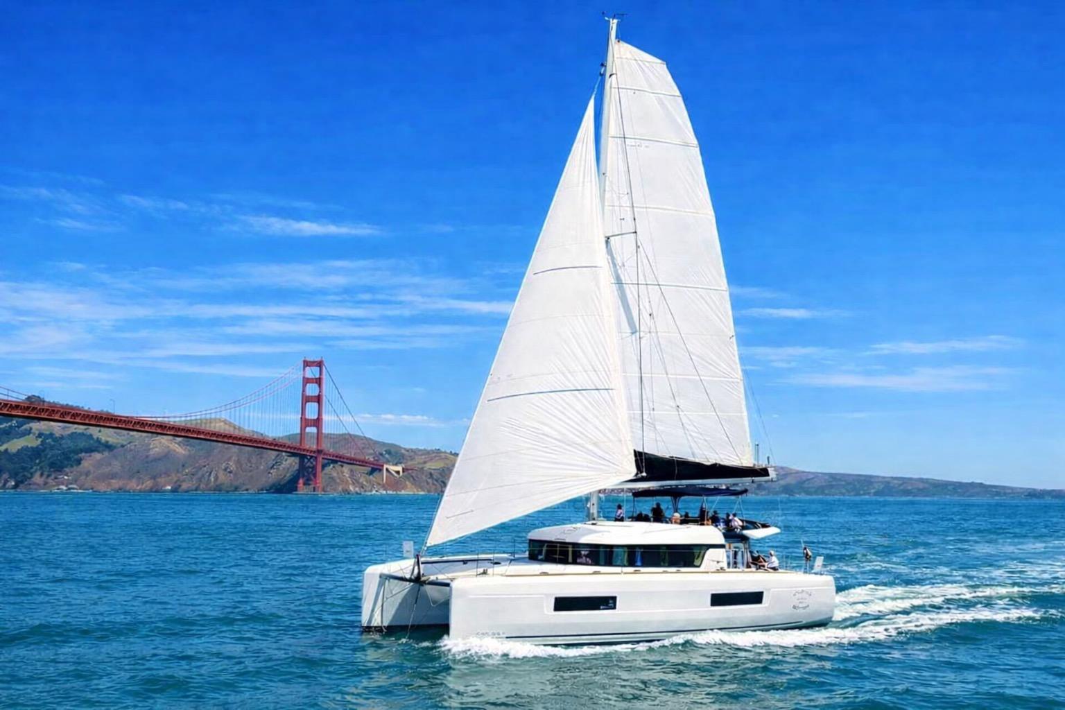 2020 Lagoon 40 catamaran sailing near Golden Gate Bridge on a sunny day.
