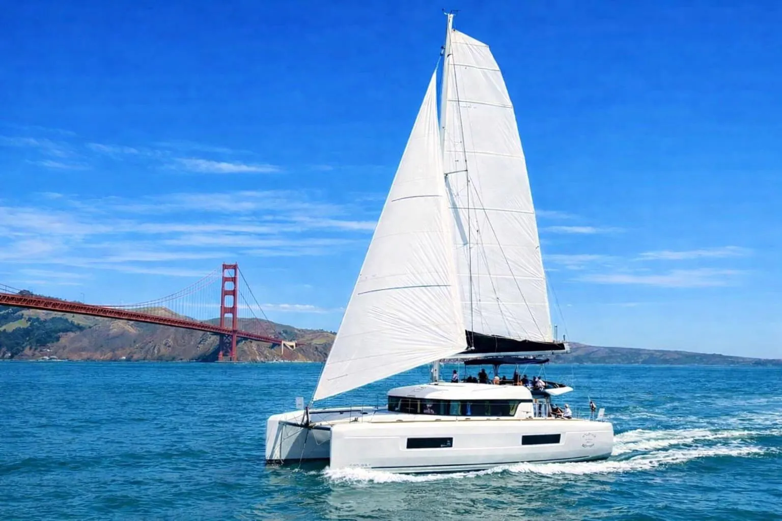 2020 Lagoon 40 catamaran sailing near Golden Gate Bridge on a sunny day.