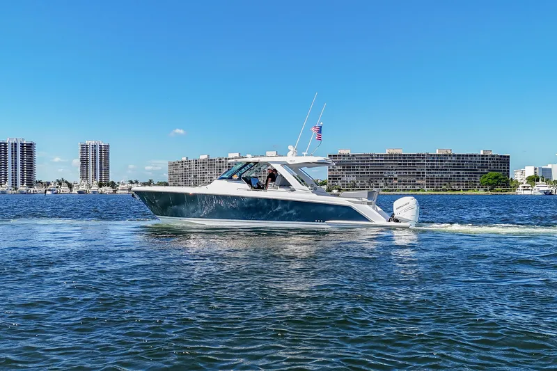 La Dolce Vita Yacht Photos Pics 2020 Tiara Yachts 38 LS cruising on a sunny day near waterfront buildings.