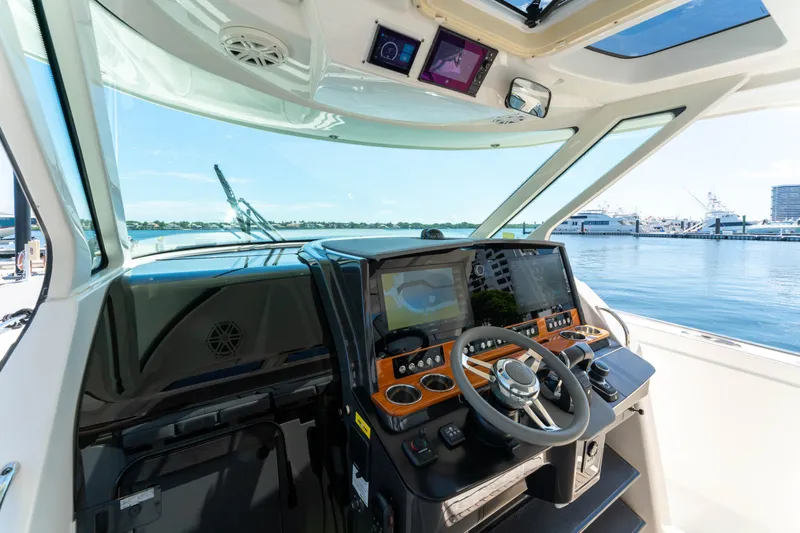 La Dolce Vita Yacht Photos Pics Cockpit of 2020 Tiara Yachts 38 LS with modern navigation equipment and waterfront view.