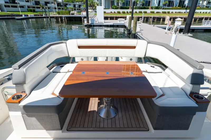 La Dolce Vita Yacht Photos Pics Luxurious seating area on 2020 Tiara Yachts 38 LS, featuring elegant wood table and waterfront view.